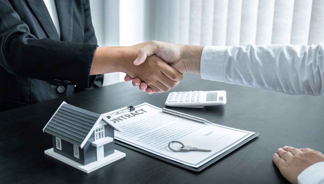Home broker and client shaking hands after signing contract approved application form e1695129576901